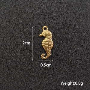Macro view of gold seahorse charm with dimensions 2cm by 0.5cm and 0.8g weight