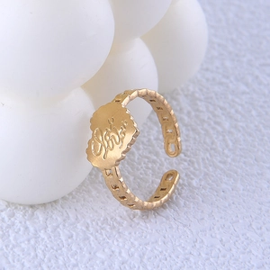 Détail d'une bague chaîne dorée avec charm fleur de cœur et gravure love ciselée