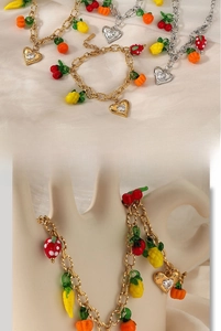 Close-up of stainless steel fruit charms and zircon heart pendants on gold and silver chains