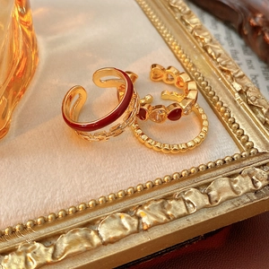 Detailed view of vintage gold ring set with heart-shaped zircon and red enamel texture