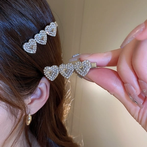 Macro view of silver star heart-shaped clips with shimmering crystals for hair
