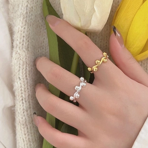 Detail of 925 sterling silver beaded rings in gold and silver on fingers