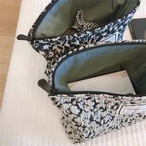 Close-up of floral makeup bags with ripple texture and dark green lining details