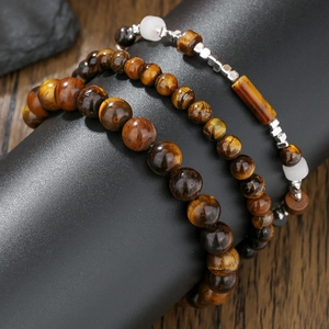 Three-piece tiger eye and hematite beaded bracelet set on a black display stand