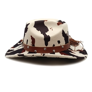 Cow print western cowboy hat with wide brim, brown rivet band and chin strap on white background