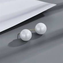 Close-up of elegant double white pearl earrings with gold-tone minimalist metal bars