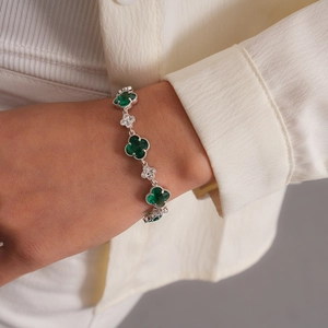 Vue détaillée du bracelet trèfle en argent avec pierres vert émeraude et zircons au poignet