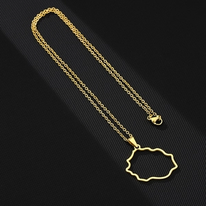 Detailed view of gold plated Reunion Island map pendant on black textured background
