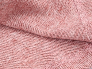 Détail en gros plan de la texture en maille rose chiné douce et des coutures de finition