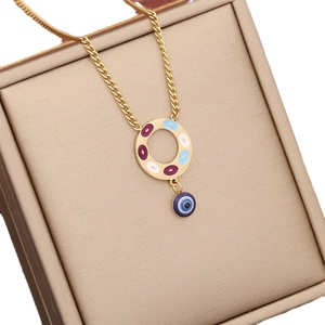 Collana in acciaio inox dorato con pendente colorato e malocchio blu su portagioie beige