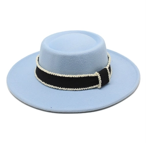Detailed texture of light blue wool felt hat with black ribbon and white pearl bead trim