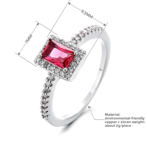 Detail view of emerald-cut red cubic zirconia ring with square halo and silver finish