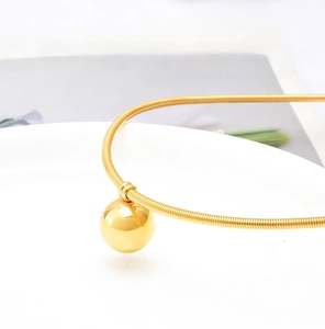 Detailed close-up of a magnetic spring chain with a polished gold orb pendant