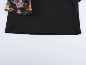 Detailed close-up of black T-shirt hem with floral mesh fabric and double stitching