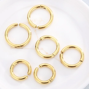 Set of six gold stainless steel coil ear clips for DIY jewelry making on a ceramic plate