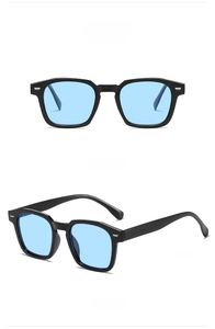 Detalle de las gafas de sol cuadradas con montura negra y lentes azul claro