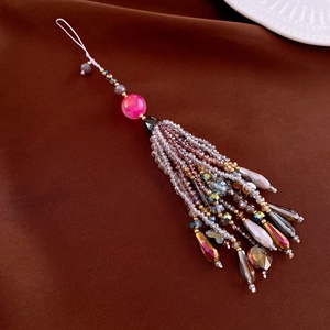 Detail view of crystal agate phone charm with pink beads and gradient glass tassels