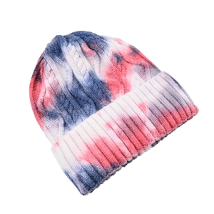 Close-up of red, blue and white tie-dye beanie with cable knit and ribbed cuff detail