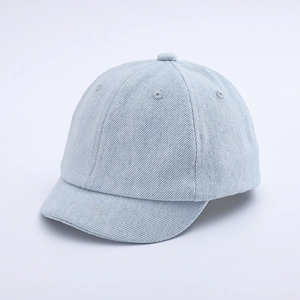 Detailed view of light blue denim fabric texture and short brim on a kids baseball cap