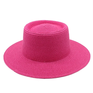 Detailed view of the woven texture and recessed crown on the rose pink straw boater hat