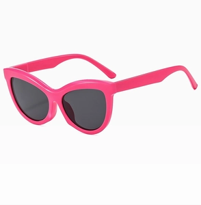 Detail view of pink cat-eye sunglasses with dark grey lenses in a 45-degree side angle