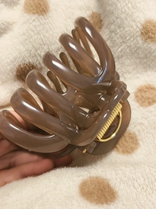 Close-up of large brown pumpkin-style shark hair claw clip with golden metal spring
