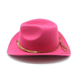 Detail of rose pink felt cowboy hat featuring colorful beaded trim and brown cord knot