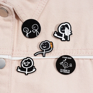 Detail of funny stickman black enamel pins on pink denim fabric background