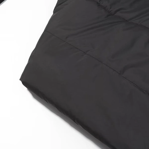 Close-up of black padded jacket detail showing glossy fabric and quilted stitching