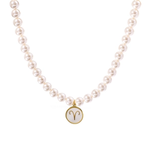 Collier signe Bélier doré à l'or 18 carats avec perle blanche sur fond blanc épuré