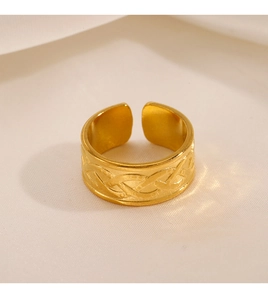 Macro detail of 18K gold plated wide band ring with intricate Celtic knot engraving