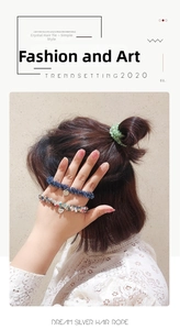 Détail de chouchous en perles de cristal bleu et vert portés au poignet et aux cheveux