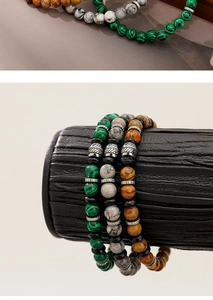 Detailed close-up of natural stone bracelets in green, grey, and brown with metal beads