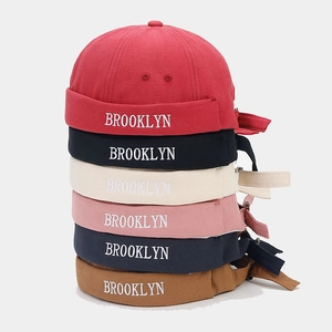 Stack of colorful retro brimless docker hats featuring Brooklyn embroidery detail