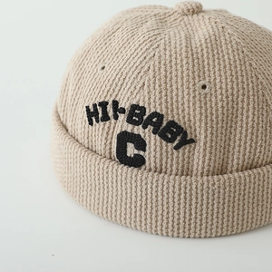 Détail du bonnet docker beige en velours côtelé avec broderie noire HI-BABY et C