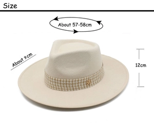Close-up of cream wool fedora hat with houndstooth band and metal M logo detail