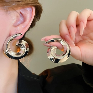 Detailed view of silver snail spiral earrings with a high-shine mirror polished finish
