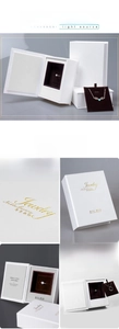 Detail of book-shaped jewelry box with white textured shell and golden foil stamping