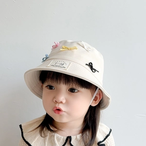 Detail of cream cotton kids sun hat with 3D colorful bow and adjustable chin strap