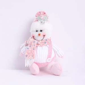 Detail of pink and white snowman plush with silver sequin bow and striped knit hat