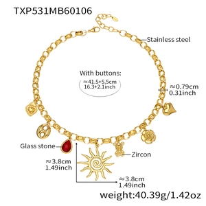 Detailed view of stainless steel necklace with red zircon heart and sun pendants