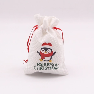 Détail du sac cadeau de Noël en toile blanche avec imprimé pingouin mignon