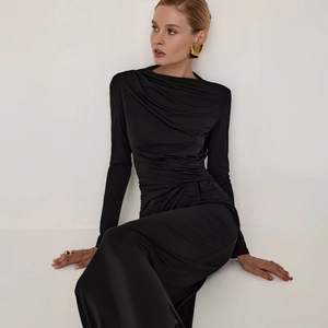 Detailed view of the elegant ruching and silky black fabric on a slim-fit evening dress