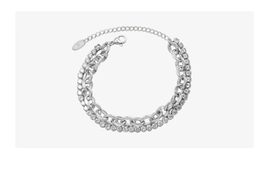 Détail du bracelet double chaîne argentée avec zircons brillants et un fermoir mousqueton