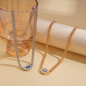 Detail of gold and silver evil eye necklaces with cubic zirconia on amber glass
