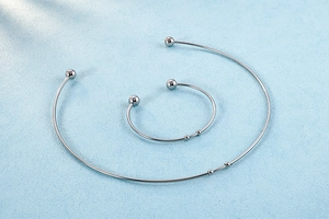 Polished silver stainless steel torque necklace and bangle set with spherical finials