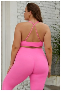 Détail d'un ensemble de yoga grande taille avec brassière croisée dans le dos rose vif