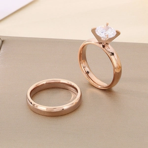 Detail of rose gold minimalist ring set with four-prong cubic zirconia and polished band