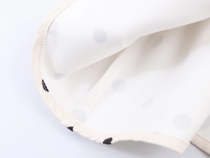 Detailed close-up showing the inner neckline and stitching of the polka dot vest