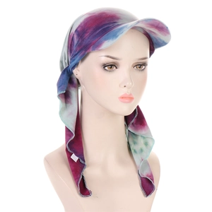 Detail of blue and purple tie-dye turban hat with curved brim shown on a model